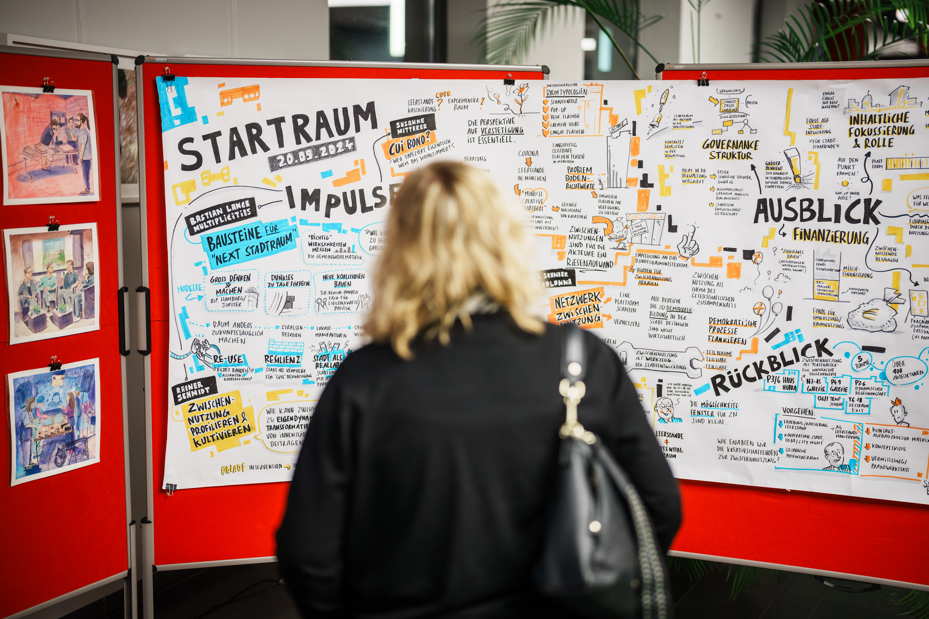 Eine Frau schaut auf ein Graphic Recording Plakat vom Projekt Startraum